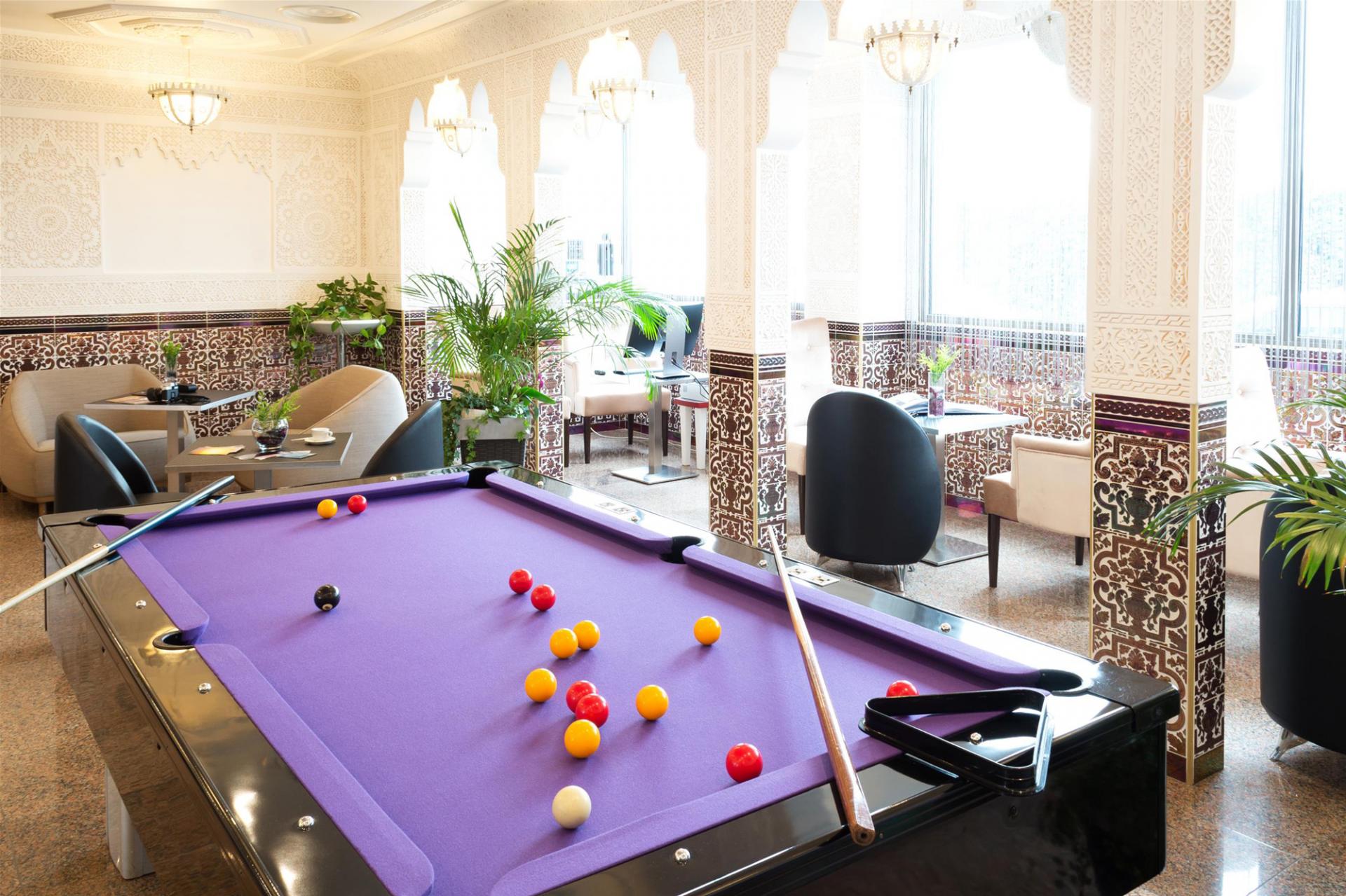 Lobby de l'hôtel avec billard, baies vitrées et coin détente
